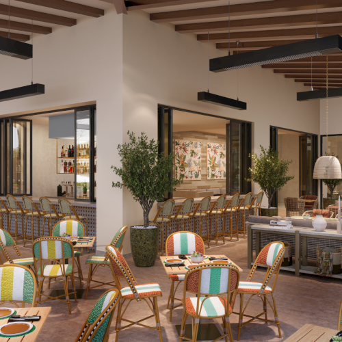 A stylish outdoor cafe and market area with striped wicker chairs, wooden tables, potted trees, and a market storefront in the background.