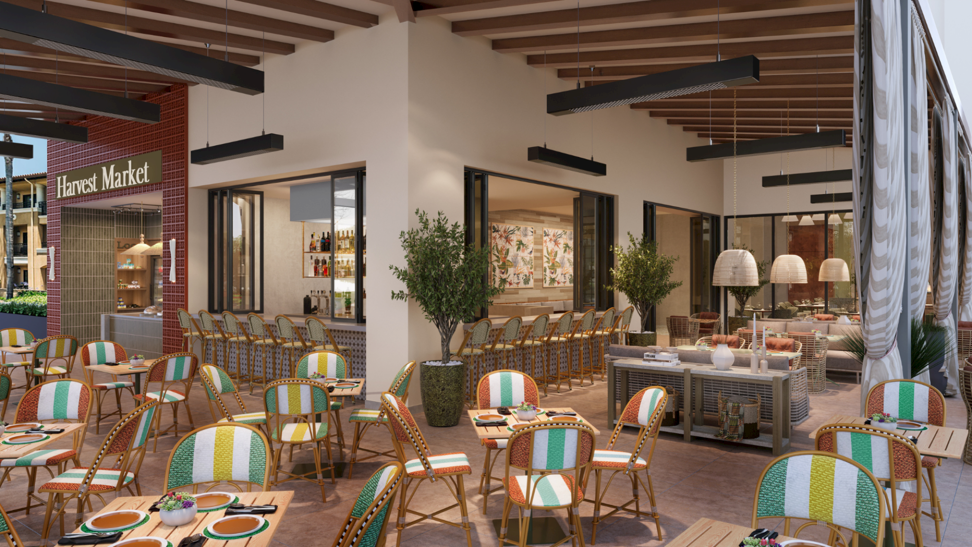 Outdoor cafe seating at a market-style storefront with colorful striped chairs, wooden tables, potted plants, and indoor lighting visible through windows.